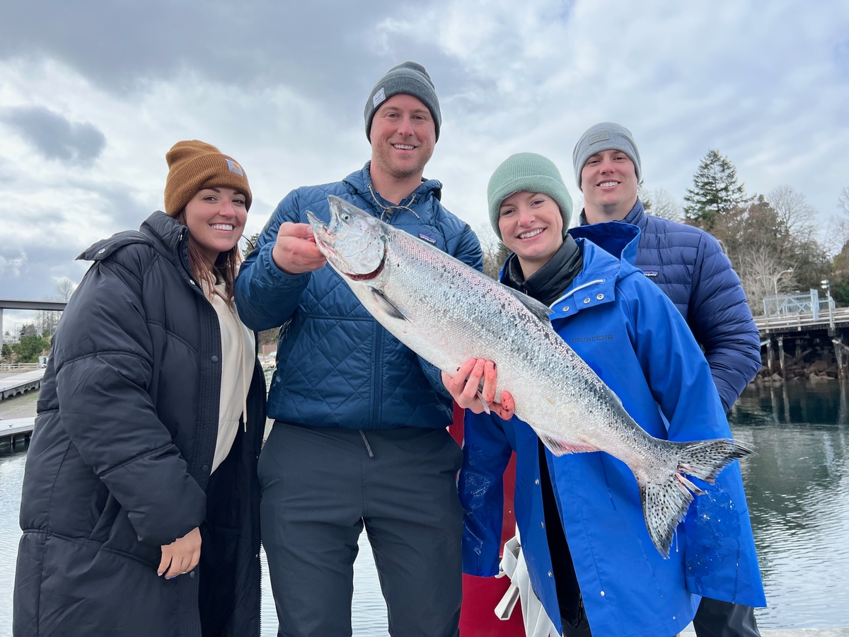 Smiling customers and a big winter blackmouth salmon caught with Cut Plug Charters