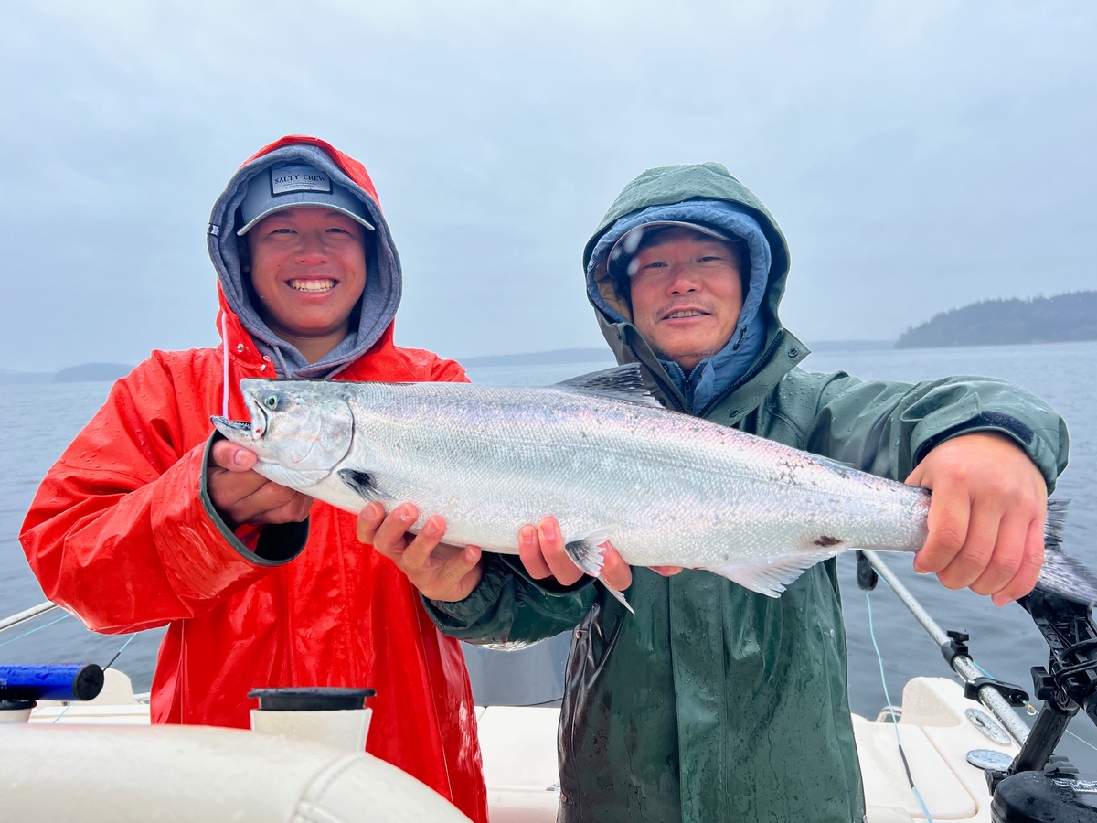 Two smiling customers with a winter Chinook salmon